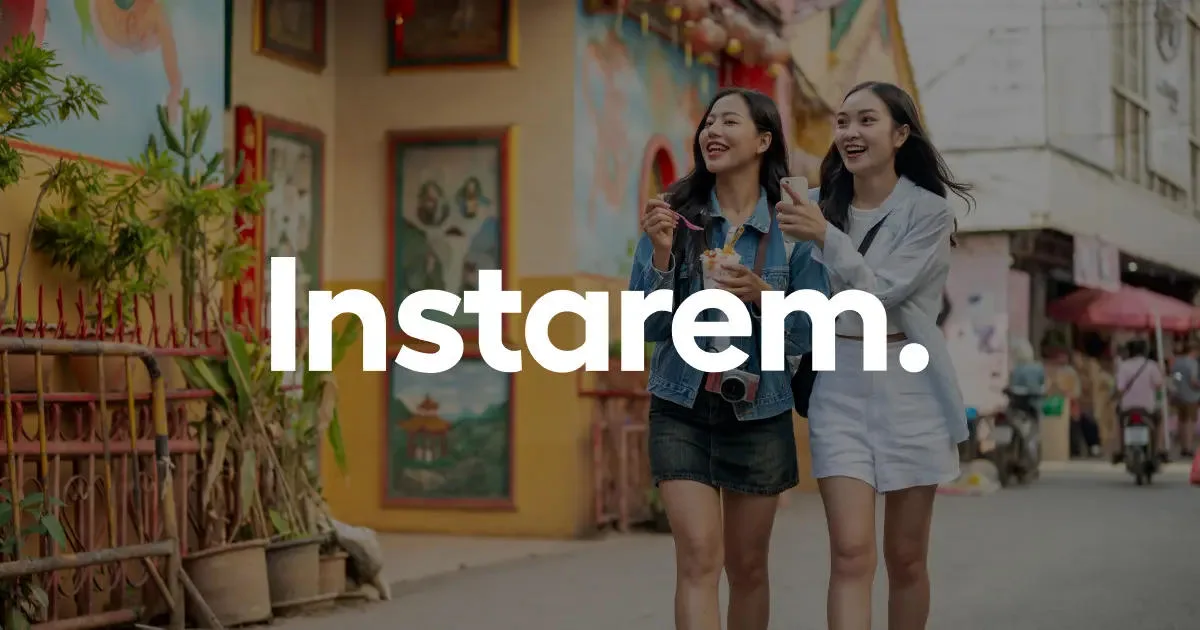 Two young women walking on a busy street, smiling and looking at their phones, with the InstaRem logo across them.